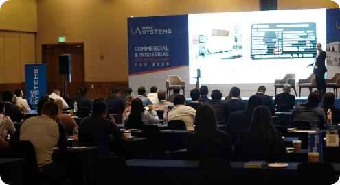 Seminario o lanzamiento de UA HVAC SYSTEMS para el sector Comercial e Industrial, con un experto presentando soluciones tecnológicas a una audiencia de ingenieros y profesionales de alto nivel.